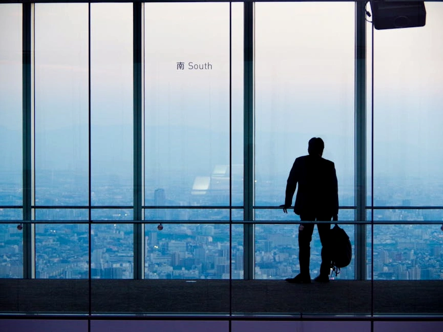 The modern architectural facade of a financial district skyscraper, reflecting the sky.